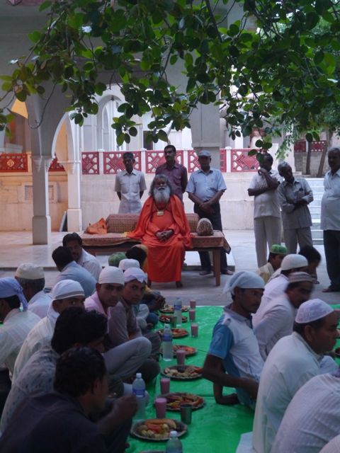 Swamiji sits with Muslims as they enjoy their feast to end Ramadan