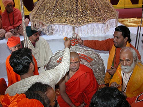 Priests are adorning Swamiji with tilak and flowers Priests are adorning Swamiji with tilak and flowers